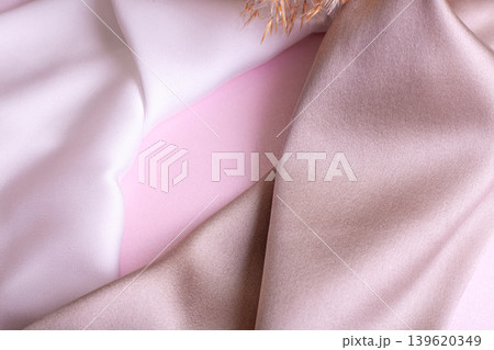 Abstract background in soft colors of silk fabrics on pink pearl paper and branch Dry beige reed. Beautiful trend texture Abstract background in soft colors of silk fabrics on pink pearl paper and branch Dry beige reed. Beautiful trend texture 139620349