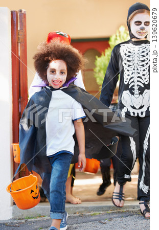 Portrait, halloween and smile with children walking in costume for trick or treat celebration together. Kids, neighborhood and candy with group of friends on street for holiday or vacation tradition Portrait, halloween and smile with children walking in costume for trick or treat celebration together. Kids, neighborhood and candy with group of friends on street for holiday or vacation tradition 139620679