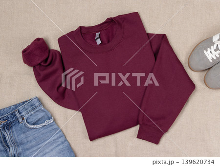 Maroon unisex sweatshirt mockup, folded flat lay with denim shorts and grey sneakers, top view 139620734