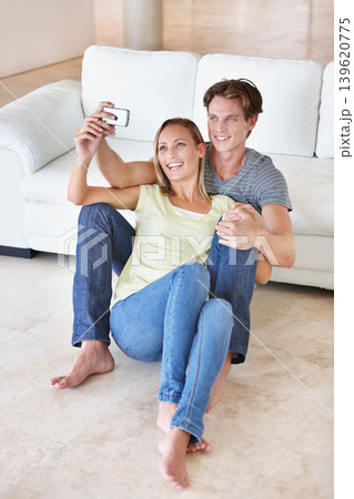 Happy, selfie and couple hug on a living room floor for bonding, photography or memory in their home. Love, photo or people embrace in living room with phone for social media, blog or profile picture Happy, selfie and couple hug on a living room floor for bonding, photography or memory in their home. Love, photo or people embrace in living room with phone for social media, blog or profile picture 139620775