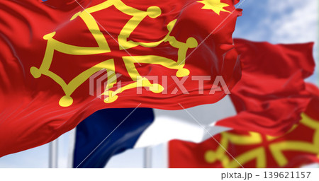 Flags of Occitanie region and France waving in the wind on a clear day Flags of Occitanie region and France waving in the wind on a clear day 139621157