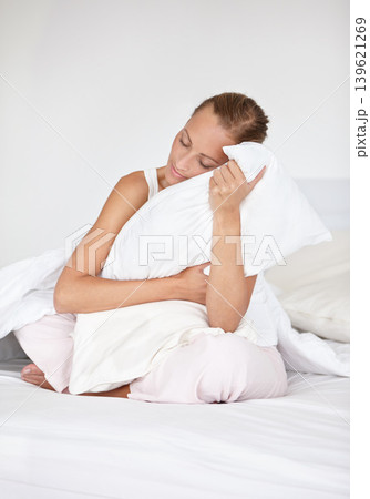 Woman, morning and pillow hug at home from sleep and nap on a bed relax and calm. Peace, wake up and bedroom with a sleepy and tired female person with comfort from sheets with dream in a house Woman, morning and pillow hug at home from sleep and nap on a bed relax and calm. Peace, wake up and bedroom with a sleepy and tired female person with comfort from sheets with dream in a house 139621269