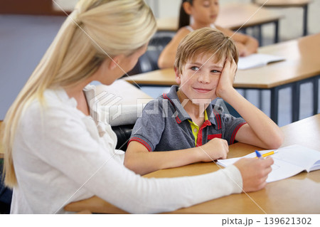 Teacher woman, boy and school to check notebook, support and knowledge for education with motivation. People, learning and development with writing, child and feedback for progress, desk or academy 139621302