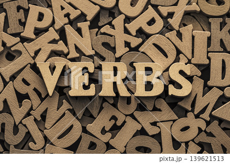 Inscription verbs on pile of old vintage wooden letters.  139621513