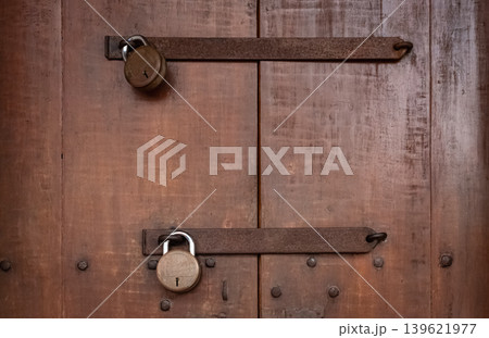 Close up photo of old wooden door with a double lock Close up photo of old wooden door with a double lock 139621977