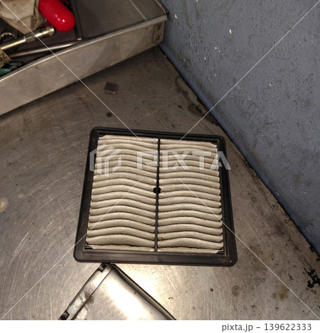 Dirty car cabin air filter on metal workbench inside garage ready for replacement service. Dirty car cabin air filter on metal workbench inside garage ready for replacement service. 139622333