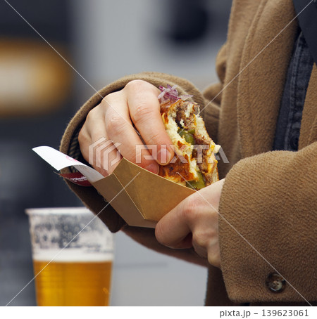 Person eating juicy street food burger in Karlin Prague Person eating juicy street food burger in Karlin Prague 139623061
