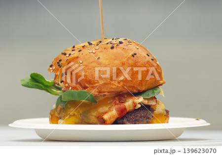 Appetizing beef burger with melted cheese and crispy bacon Appetizing beef burger with melted cheese and crispy bacon 139623070