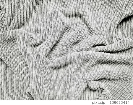 gray knitted ribbed sweater fabric texture with soft crumpled folds and intricate shadows gray knitted ribbed sweater fabric texture with soft crumpled folds and intricate shadows 139623414
