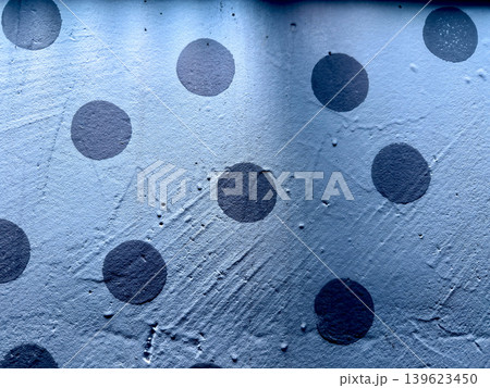 abstract blue wall with irregular dark polka dots textured painted surface macro closeup 139623450