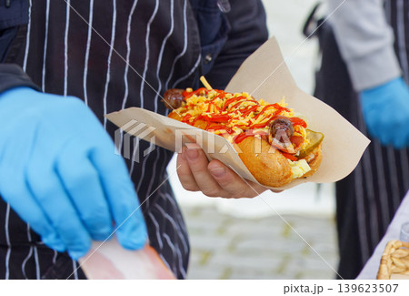Street food vendor serving loaded hot dog at Naplavka Street food vendor serving loaded hot dog at Naplavka 139623507