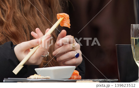 Woman Eating Salmon Sushi with Copy Space Woman Eating Salmon Sushi with Copy Space 139623512