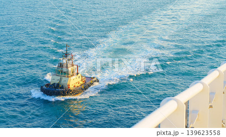 Manama, Bahrain - Jan 08 2024, Aerial view of tugboat, boat, what passing by, with blue sea, at daytime, Manama, Bahrain Manama, Bahrain - Jan 08 2024, Aerial view of tugboat, boat, what passing by, with blue sea, at daytime, Manama, Bahrain 139623558