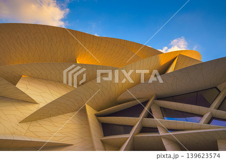 Doha, Qatar - Jan 06 2024, a panoramic view of National Museum of Qatar facade, exterior, shaped like a desert rose, at evening with blue sky, Doha, Qatar Doha, Qatar - Jan 06 2024, a panoramic view of National Museum of Qatar facade, exterior, shaped like a desert rose, at evening with blue sky, Doha, Qatar 139623574