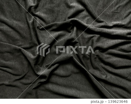 crumpled charcoal fabric drapes dramatically into textured folds revealing deep shadows and rich woven texture crumpled charcoal fabric drapes dramatically into textured folds revealing deep shadows and rich woven texture 139623646
