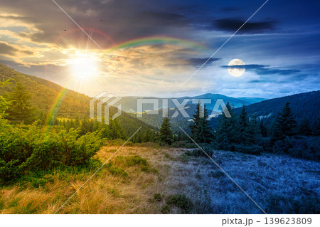 hillside of mountain range with coniferous forest and grassy meadow. day meet night. sun and moon over beautiful summer landscape with alp. wonderful nature background of highland for earth day 139623809