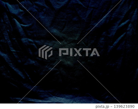 crumpled deep navy velvet fabric folds create dramatic chiaroscuro shadows in intimate abstract macro texture 139623890