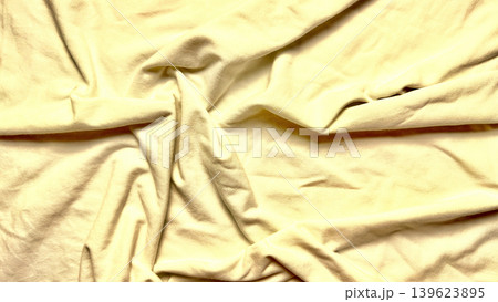 crumpled pale yellow fabric twists into deep intricate wrinkles with soft shadows creating serene tactile texture crumpled pale yellow fabric twists into deep intricate wrinkles with soft shadows creating serene tactile texture 139623895