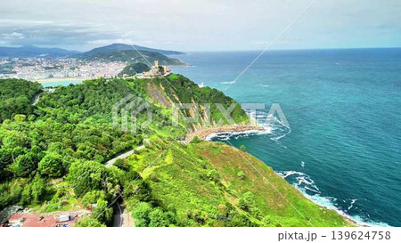 A Scenic Coastal View Featuring Lush Green Hills, Inviting Ocean Waves, and a Peaceful Atmosphere A Scenic Coastal View Featuring Lush Green Hills, Inviting Ocean Waves, and a Peaceful Atmosphere 139624758