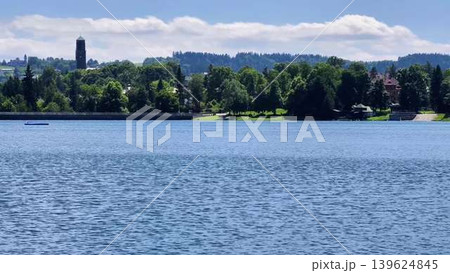Experience the breathtaking scenic view of a stunning lake featuring a sailboat and a tower 139624845