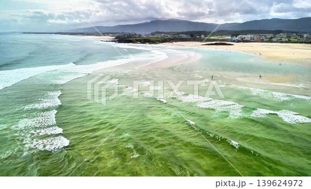 Experience the tranquil beauty of serene coastal waves accompanied by a scenic beach view 139624972