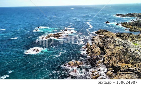 Powerful ocean waves crash on the rugged coastline, creating an aweinspiring scene 139624987
