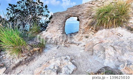 Breathtaking Scenic Sea View Through a Majestic Rock Arch on the Beautiful Coastal Landscape Breathtaking Scenic Sea View Through a Majestic Rock Arch on the Beautiful Coastal Landscape 139625010
