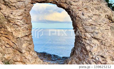 Captivating Scenic Coastal View Through a Beautiful Natural Rock Arch by the Ocean 139625212