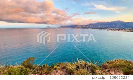Breathtaking Serene Coastal View at Sunset with Majestic Mountains in the Background 139625224