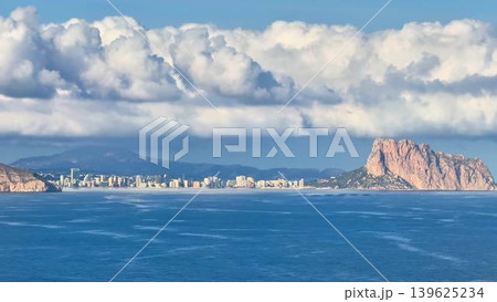 Experience a stunning seaside view that features rocky outcrops and a cloudy sky above Experience a stunning seaside view that features rocky outcrops and a cloudy sky above 139625234