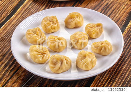 Plate of traditional steamed dumplings Momo on a table. Asian cuisine concept. 139625394