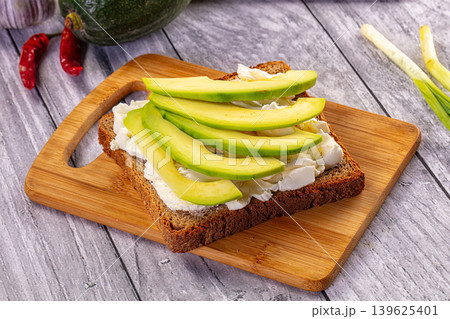 Avocado toast with cream cheese on rye bread with fresh ingredients 139625401