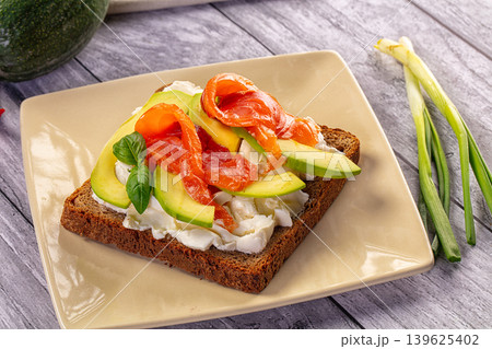 Smoked Salmon and Avocado Toast with Cream Cheese on Rustic Wood Table Smoked Salmon and Avocado Toast with Cream Cheese on Rustic Wood Table 139625402