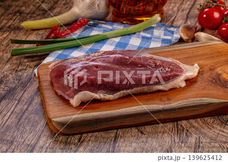 Raw duck breast on wooden board with fresh ingredients Raw duck breast on wooden board with fresh ingredients 139625412