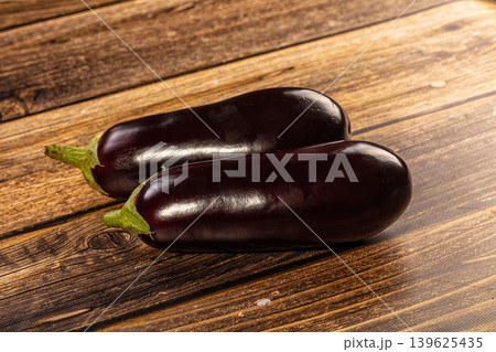 Fresh purple eggplants on rustic wooden background Fresh purple eggplants on rustic wooden background 139625435