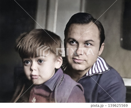 A vintage portrait of a father and son. The son is looking at something with fascination. Retro photo, 1973 A vintage portrait of a father and son. The son is looking at something with fascination. Retro photo, 1973 139625569
