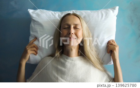 Healthy sleep, happy relaxed sleepy young woman on white soft comfortable pillow 139625780