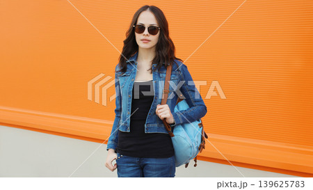 Young woman with backpack , modern teenage girl posing on city street Young woman with backpack , modern teenage girl posing on city street 139625783