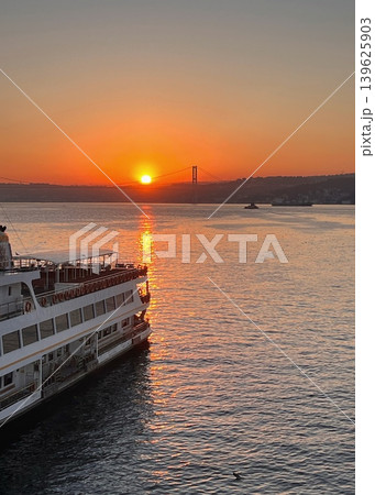 Sunset over the water with a ferry docked at the shore, silhouette Sunset over the water with a ferry docked at the shore, silhouette 139625903