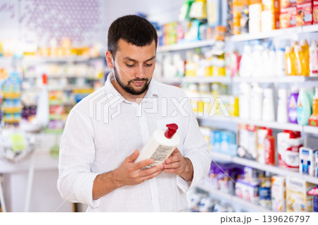 Portrait of man choosing hair care product in drugstore Portrait of man choosing hair care product in drugstore 139626797