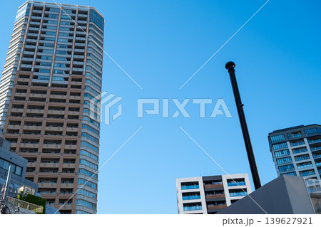 青空にそびえる都市の高層マンションと煙突のシルエット 青空にそびえる都市の高層マンションと煙突のシルエット 139627921