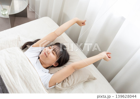 ベッドで伸びをする女性 ベッドで伸びをする女性 139628044