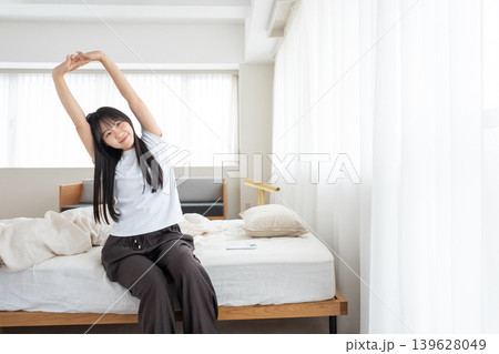 朝のベッドの上で伸びをする女性 139628049