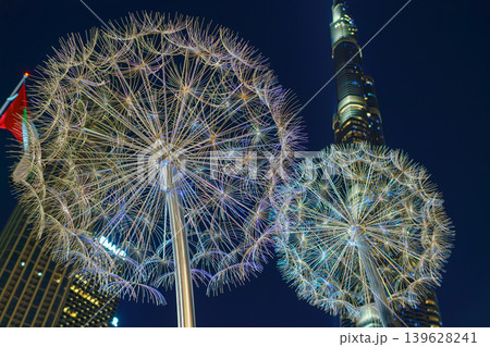 Dubai, United Arab Emirates - Jan 19 2024, panoramic view of the Burj Khalifa tower through giant metal glowing dandelions, on the square, at nighttime with the illumination , Dubai, UAE 139628241