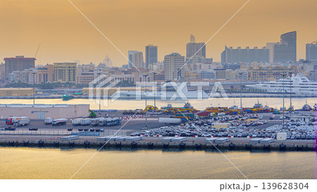 Dubai, United Arab Emirates - Jan 19 2024, Panoramic view of Dubai port with various ships and luxury yachts moored, with urban buildings in the background, in the evening, Dubai, UAE Dubai, United Arab Emirates - Jan 19 2024, Panoramic view of Dubai port with various ships and luxury yachts moored, with urban buildings in the background, in the evening, Dubai, UAE 139628304
