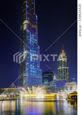 Dubai, United Arab Emirates - Jan 19 2024, view of the pool with dancing fountains and the Burj Khalifa tower, at nighttime, with illumination and street light, Dubai, UAE Dubai, United Arab Emirates - Jan 19 2024, view of the pool with dancing fountains and the Burj Khalifa tower, at nighttime, with illumination and street light, Dubai, UAE 139628320