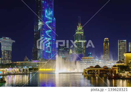 Dubai, United Arab Emirates - Jan 19 2024, panoramic view of the pool with dancing fountains and the Burj Khalifa tower, at nighttime, with illumination and street light, Dubai, UAE Dubai, United Arab Emirates - Jan 19 2024, panoramic view of the pool with dancing fountains and the Burj Khalifa tower, at nighttime, with illumination and street light, Dubai, UAE 139628321