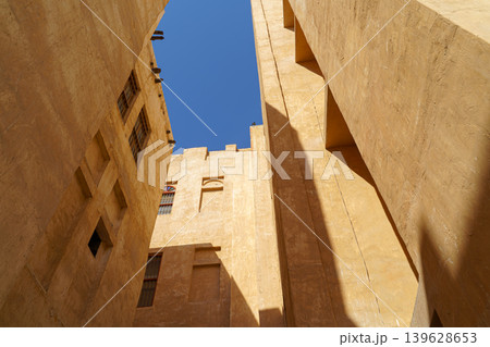Doha, Qatar - Jan 14 2024, Bottom-up view of the narrow courtyard of the well, the blue sky is visible on top, in Souq Waqif area, at daytime, Doha, Qatar 139628653