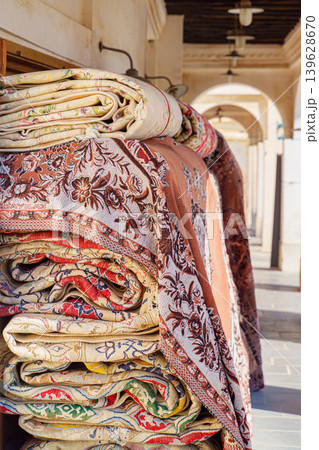 Doha, Qatar - Jan 14 2024, Close up view of a pile of Persian carpets and clothes rolled up and stacked, at Souq Waqif bazaar area, at daytime, Doha, Qatar Doha, Qatar - Jan 14 2024, Close up view of a pile of Persian carpets and clothes rolled up and stacked, at Souq Waqif bazaar area, at daytime, Doha, Qatar 139628670