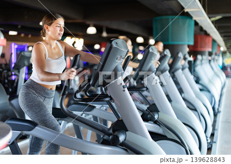 Young woman working out on elliptical machine Young woman working out on elliptical machine 139628843